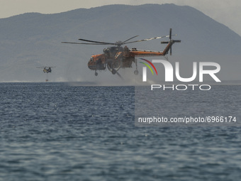 Firefighter helocopter revealed with water during a wildfire in the area of Villia north-western of Athens, Greece, 17 August 2021. (