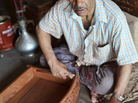 Kashmiri craftsman polishes a hand carved walnut drawer in a small floating workshop on Dal Lake in Srinagar, Kashmir, India, on June 26, 20...