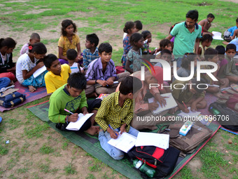 An Indian student who prepares for competetive exams,teaches a primary education to children of slums in Allahabad on July 19,2015.They educ...