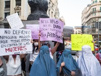 Protesters are seen with burqas and banners that say, I do not defend any religion because they are all against women and neither the veil n...