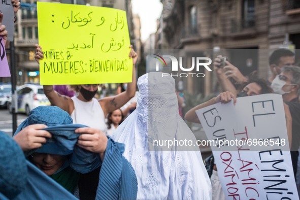 Protester is seen wearing a burqa and another is seen removing the burqa.Around a hundred women have participated in a feminist demonstrati...