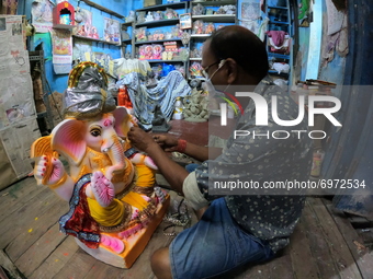An artisan works on eco-friendly figures of the Hindu deity Ganesh, made with mud, jute fiber and bamboo to reduce water pollution during th...