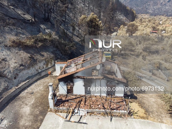 Burned houses near Agia Anna. Panoramic aerial bird's eye view of a drone shows devastating aftermath of wildfires in Evia island in Greece...