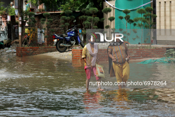 Women walk through a flooded street after heavy rains in Ghaziabad, a suburb of New Delhi, India on August 21, 2021.  Intense rains lashed t...