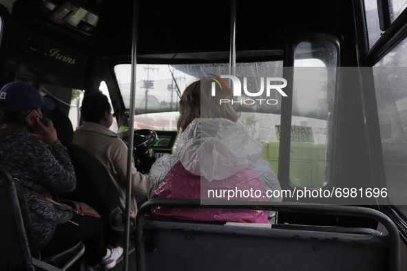 A woman aboard a bus carrying a windbreaker jacket after rains and strong gusts of wind in Mexico City due to Hurricane Grace, which is adva...