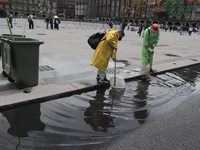 Clean-up workers unclog drains in the Historic Centre of Mexico City after heavy rains and strong gusts of wind due to Hurricane Grace, whic...