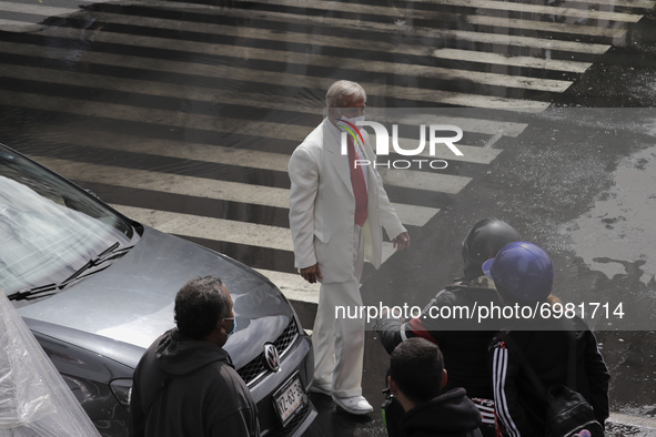 A person wears a white suit on Eje Central in Mexico City while rains and strong gusts of wind are recorded due to Hurricane Grace that adva...