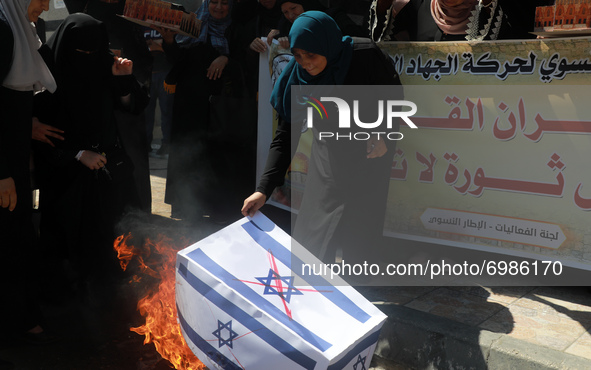 Palestinian women burning an Israeli national flag during a protest marking the anniversary of a 1969 arson attack at Jerusalem's Al-Aqsa mo...