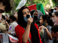 An Afghan woman living in Delhi participates in a protest appealing international community to come forward to help refugees after Taliban's...