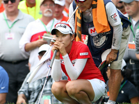 Chella Choi of South Korea lines up her putt with her father and caddy Ji Yeon Choi standing behind her on the 18th green in a playoff hole...