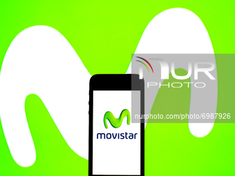 In this photo illustration a Movistar logo seen displayed on a smartphone with a Movistar logo in the background. (