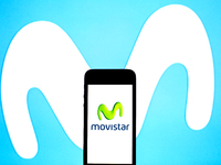 In this photo illustration a Movistar logo seen displayed on a smartphone with a Movistar logo in the background. (