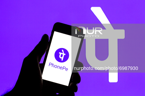 In this photo illustration a PhonePe logo seen displayed on a smartphone with a PhonePe logo in the background. 