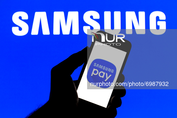 In this photo illustration a Samsung Pay logo seen displayed on a smartphone with a Samsung Pay logo in the background. 