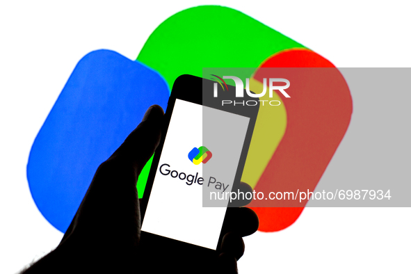 In this photo illustration a Google Pay logo seen displayed on a smartphone with a Google Pay logo in the background. 