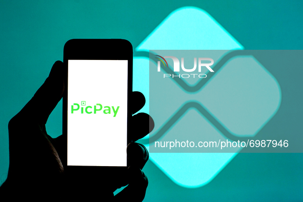 In this photo illustration a PicPay logo seen displayed on a smartphone with a Pix logo in the background. 