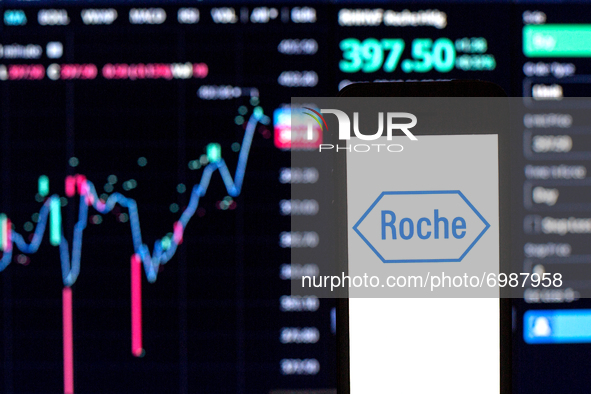 In this photo illustration a Hoffmann–La Roche logo seen displayed on a smartphone with the stock market information of Hoffmann–La Roche in...