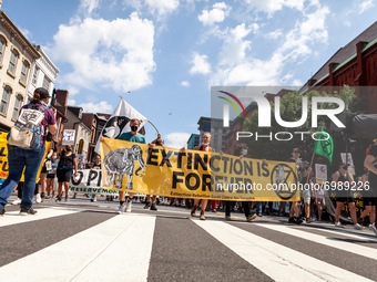 New Hampshire Extinction Rebellion members carry a banner in a march of hundreds of protesters against Enbridge's Line 3 oil pipeline, spons...