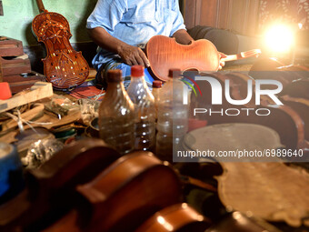 Pachugopal Roy showing a beautifully crafted violin in his workshop in Kolkata, India, on August 24, 2021. Born in the year 1945 and started...