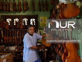 Pachugopal Roy showing a beautifully crafted violin in his workshop in Kolkata, India, on August 24, 2021. Born in the year 1945 and started...