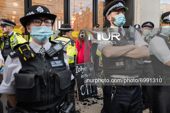 LONDON, UNITED KINGDOM - AUGUST 24, 2021: Environmental activists from Extinction Rebellion are surrounded by police officers as they protes...