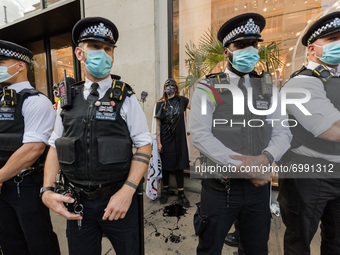 LONDON, UNITED KINGDOM - AUGUST 24, 2021: Environmental activists from Extinction Rebellion are surrounded by police officers as they protes...
