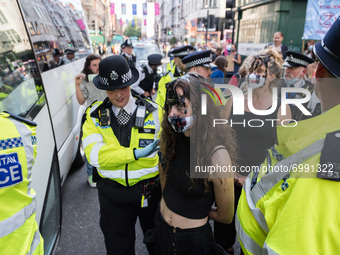 LONDON, UNITED KINGDOM - AUGUST 24, 2021: Environmental activists from Extinction Rebellion are arrested and led away by police officers fol...