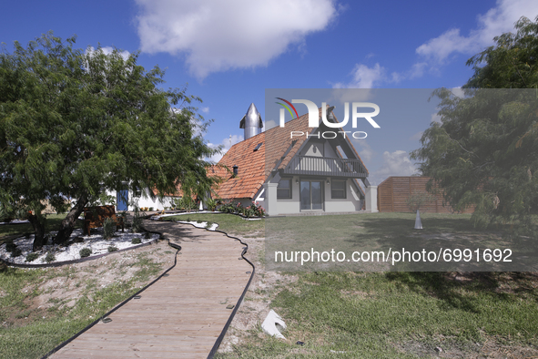 Starship SN16 is seen behind a house that remains in the Boca Chica Village in Brownsville, Texas on August 24th, 2021.  