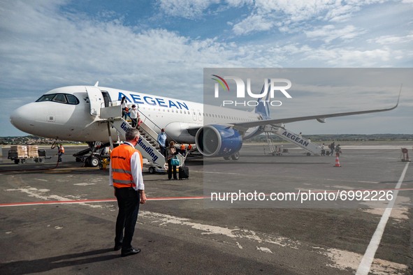 Passengers are disembarking an Aegean Airlines Airbus A320neo walking towards the airport terminal after a domestic flight from Athens while...
