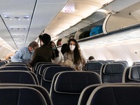 Passengers inside the cabin of an airplane are disembarking an Aegean Airlines Airbus A320neo after a domestic flight from Athens while they...