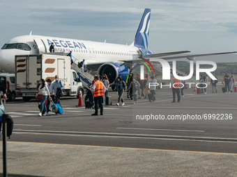 Passengers are disembarking an Aegean Airlines Airbus A320neo walking towards the airport terminal after a domestic flight from Athens while...