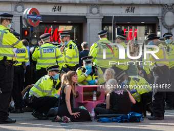 LONDON, UNITED KINGDOM - AUGUST 25, 2021: Police officers speak to environmental activists from Extinction Rebellion who are locked-on in Ox...