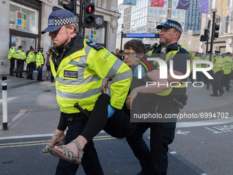 LONDON, UNITED KINGDOM - AUGUST 25, 2021: Police officers arrest an environmental activists from Extinction Rebellion for blocking Oxford Ci...
