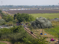 A view over a barbwire fence erected by Hungary at the border line between Serbia and Hungary in Roszke, southern Hungary on September 14, 2...