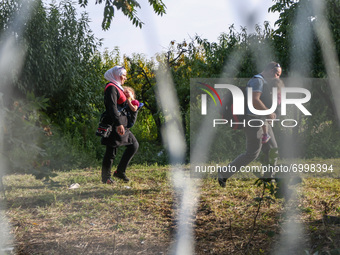 Refugees are walking along the barbed wire separating Hungary and Serbia at the border line in Roszke, southern Hungary on September 14, 201...