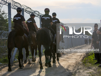 Hungarian police on horses is riding along a barbwire fence at the border line between Serbia and Hungary in Roszke, southern Hungary on Sep...