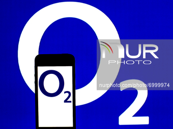 In this photo illustration a O2 logo seen displayed on a smartphone with a O2 logo in the background. (