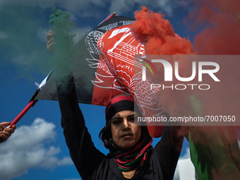 Protester lights a flare in the colors of Afghanistan.
Members of the local Afghan diaspora, activists and local supporters seen in front of...