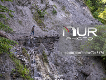 Motorists cross the Trans Palu-Kulawi Road which is buried by landslide material in Namo Village, Sigi Regency, Central Sulawesi Province, I...