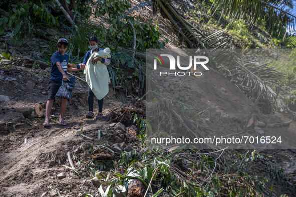 Residents were forced to walk across the Trans Palu-Kulawi Road which was buried by landslide material in Namo Village, Sigi Regency, Centra...