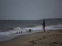 A woman fishes as remnants of Hurrican Ida hit Cape May Point, New Jersey, the southern-most tip of the state on September 1, 2021 (