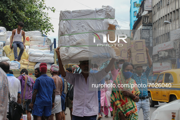 Migrant labour move goods across a wholesale Market after it reopened under the Unlock guidelines in Kolkata, India September 03,2021. 