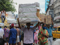 Migrant labour move goods across a wholesale Market after it reopened under the Unlock guidelines in Kolkata, India September 03,2021. (