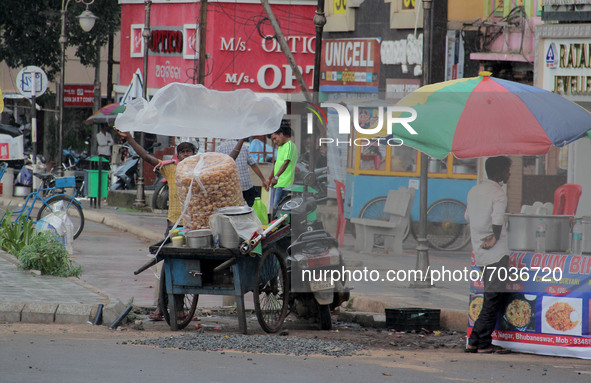 A way side snacks vendor covers his vending business trolley before the downpour in the eastern Indian state Odisha's capital city Bhubanesw...
