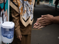 A student disinfects his hands before entering the classroom, in South Tangerang, Indonesia, on September 6, 2021. Indonesia government ease...