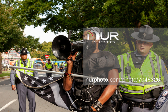 Virginia state troopers escort Jappari Jones of Richmond out of the barricaded area as the statue of Confederate general Robert E. Lee is re...