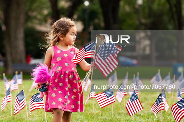 A young girl helps collect American flags from the National Mall.  2,977 flags were placed near the Capitol, one for each victim of the Sept...