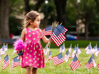 A young girl helps collect American flags from the National Mall.  2,977 flags were placed near the Capitol, one for each victim of the Sept...