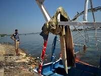 Egyptians watch rescue workers look for victims of a passenger boat after it sunk in the river Nile in Giza, south of Cairo, Egypt, Thursday...