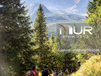 Tourists walk a mountain trail in the area of Black Lake and Granat summits in Tatra mountains, Poland as warm weekend attracted crowds on t...
